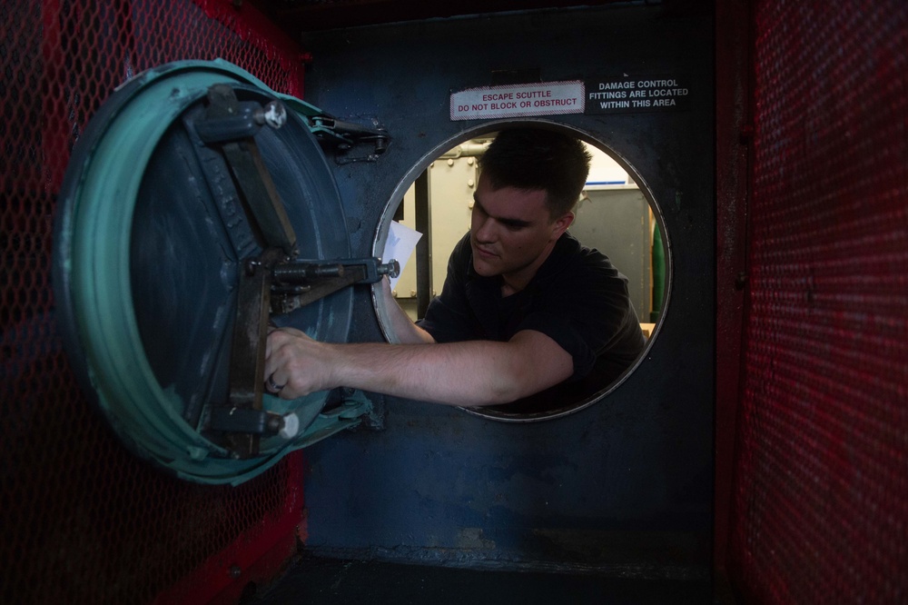 U.S. Sailor sands a scuttle