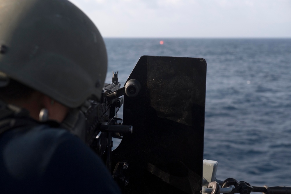 U.S. Navy Gunner’s Mate 2nd Class Brandon Diep, from Riverside, California, fires an M240B machine gun at an inflatable target