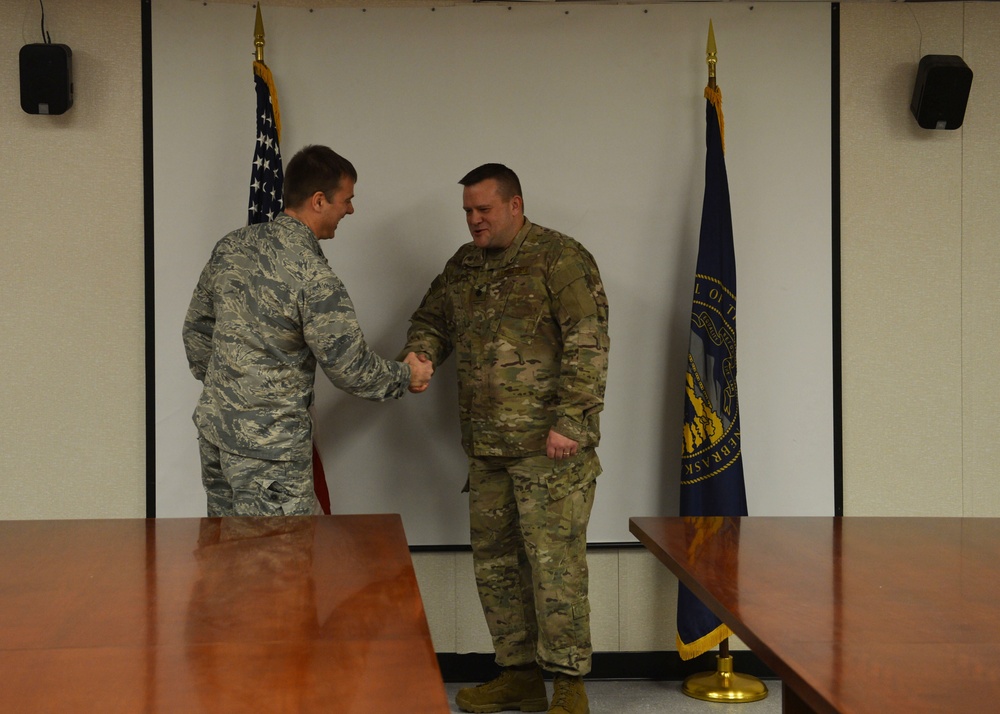 Lt. Col. John shakes Col. Christopher Hesse's hand during promotion ceremony