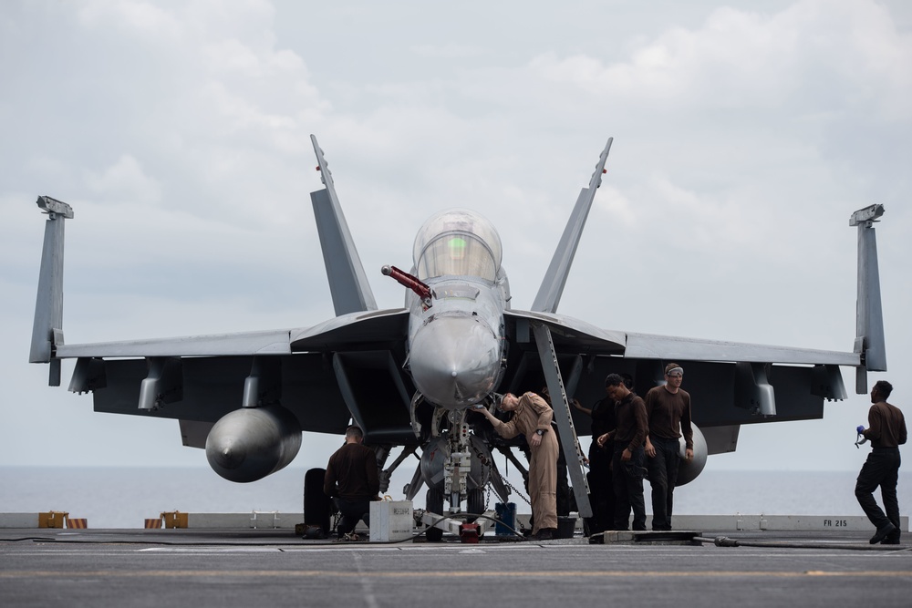 U.S. Sailors clean an F/A-18F Super Hornet