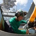 U.S. Sailor cleans mechanics on an MH-60S Sea Hawk