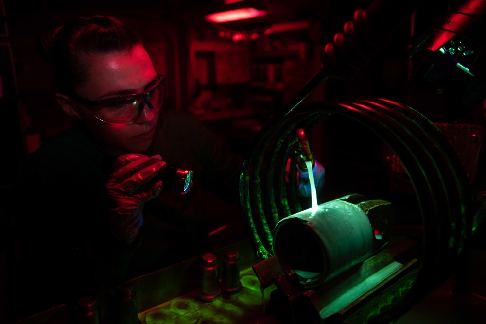 U.S. Sailor conducts a magnetic particle inspection