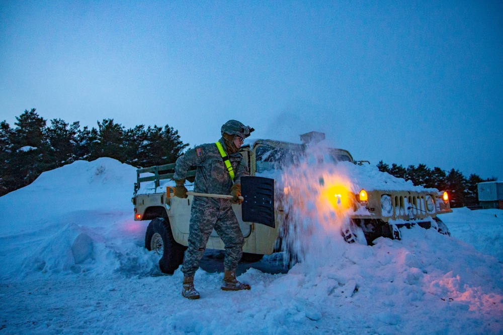 Soldier digs vehicle out of snow