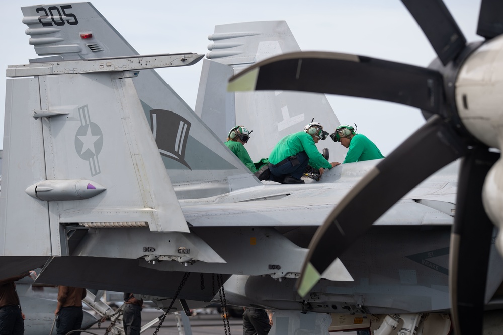 U.S. Sailors conduct maintenance on an F/A-18E Super Hornet