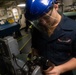 U.S. Sailor grinds down a metal washer
