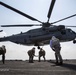 Marines brace themselves as a CH-53E Super Stallion takes off