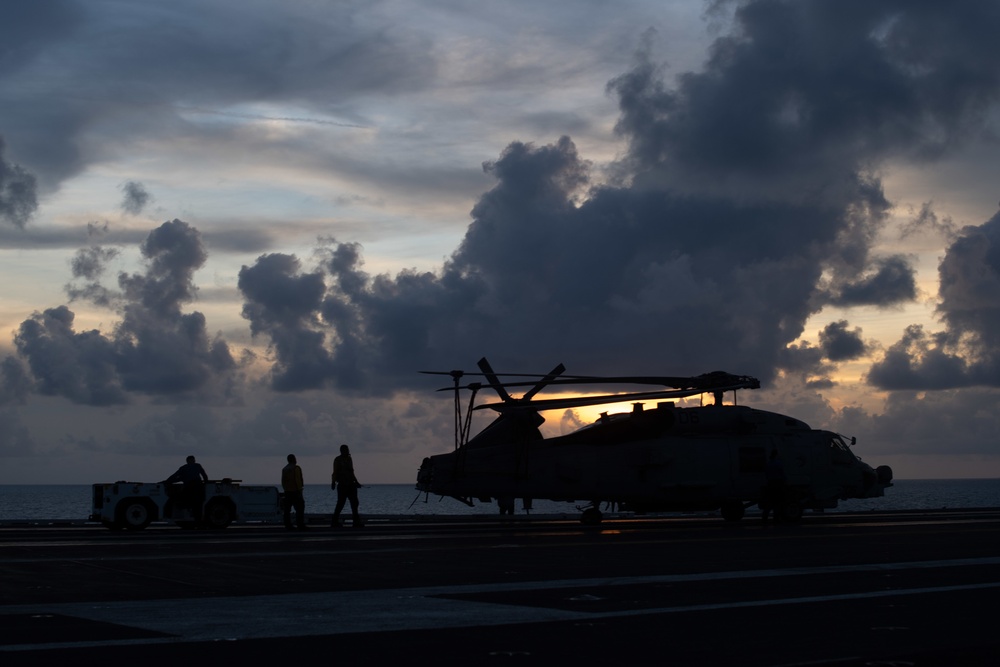 U.S. Sailors taxi an MH-60R Sea Hawk