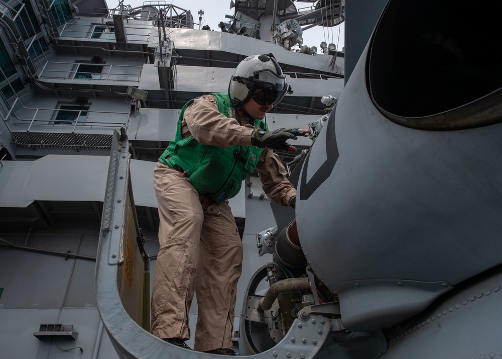 U.S. Sailor conducts pre-flight, check on an MH-60R Sea Hawk