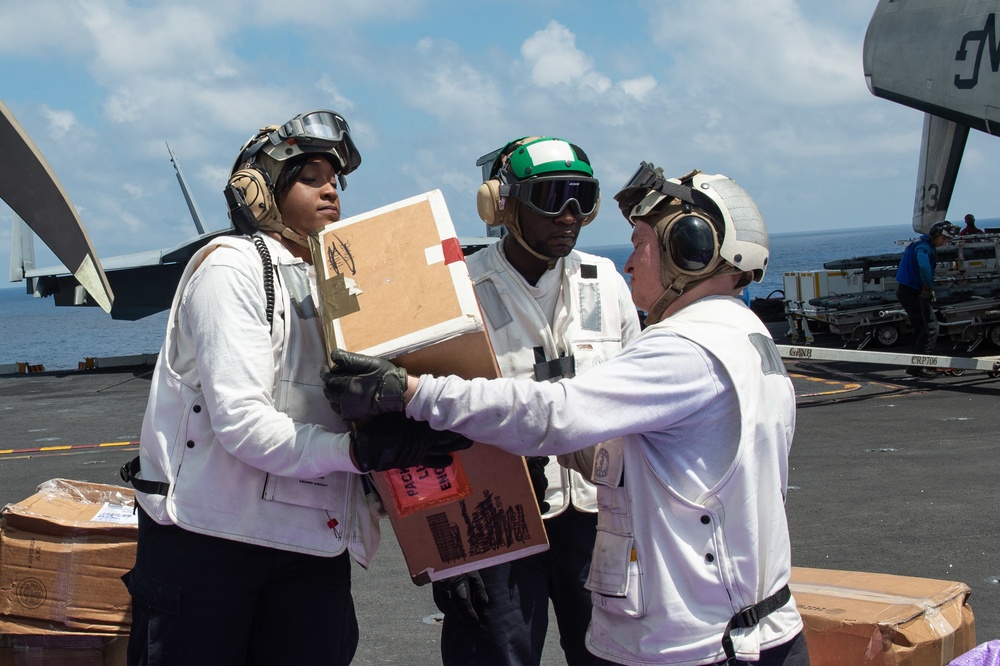 U.S. Sailors move packages