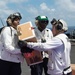 U.S. Sailors move packages