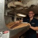 U.S. Sailor places cardboard into a pulper