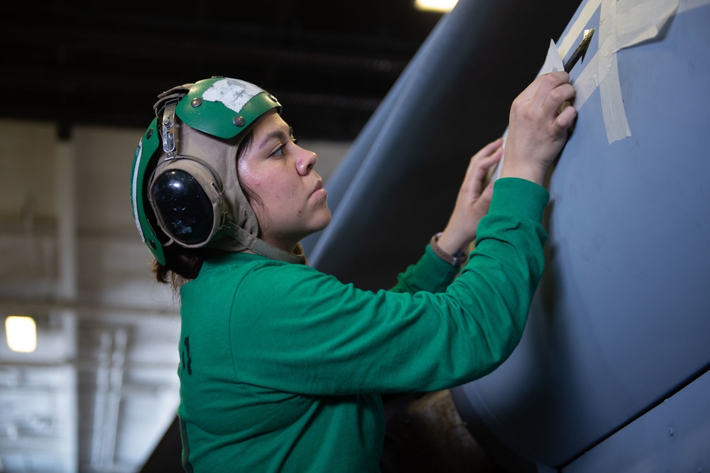 U.S. Sailor stencils an MH-60S Sea Hawk