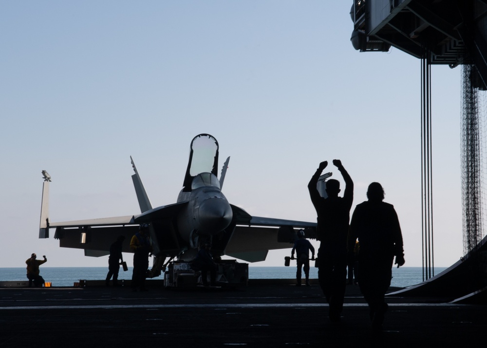 U.S. Sailor directs an an F/A-18E Super Hornet