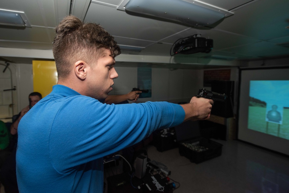 U.S. Sailor trains with an M9 pistol fitted for a Multiple Interactive Learning/Training Objectives Range
