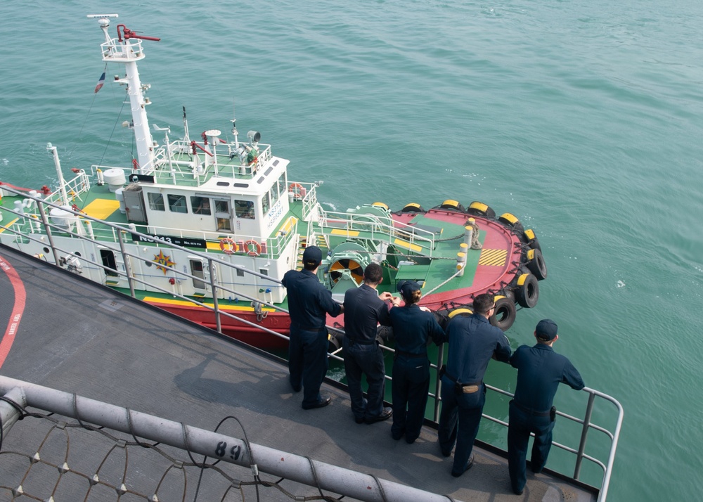 U.S. Sailors observe a tug boat