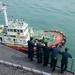 U.S. Sailors observe a tug boat