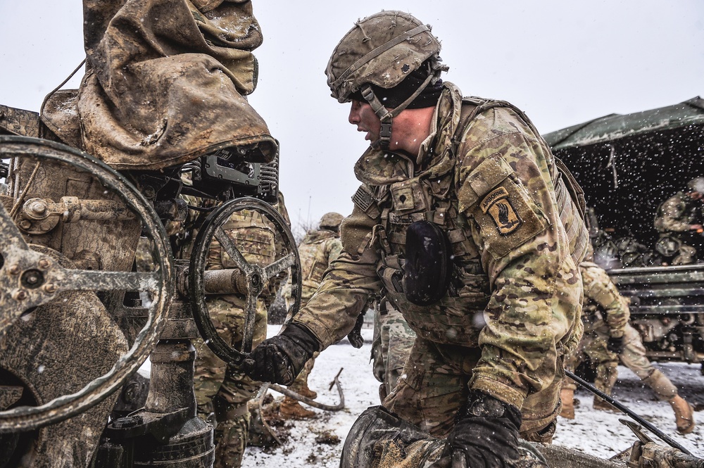 Paratrooper helps to emplace howitzer