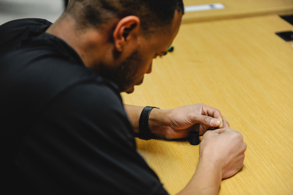 Soldier threads needle after exercise