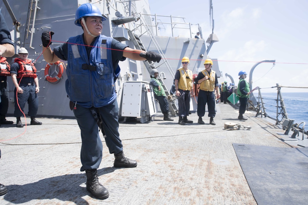 U.S. Navy Boatswain’s Mate heaves in line during a replenishment-at-sea