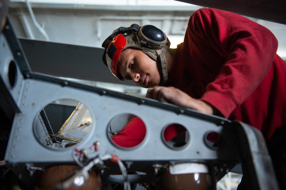 U.S. Sailor shunts fire bottle caps on an MH-60S Sea Hawk