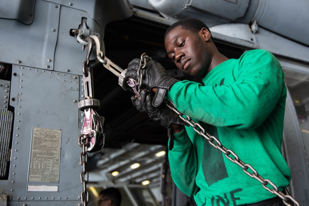 U.S. Sailor ties down an MH-60S Sea Hawk