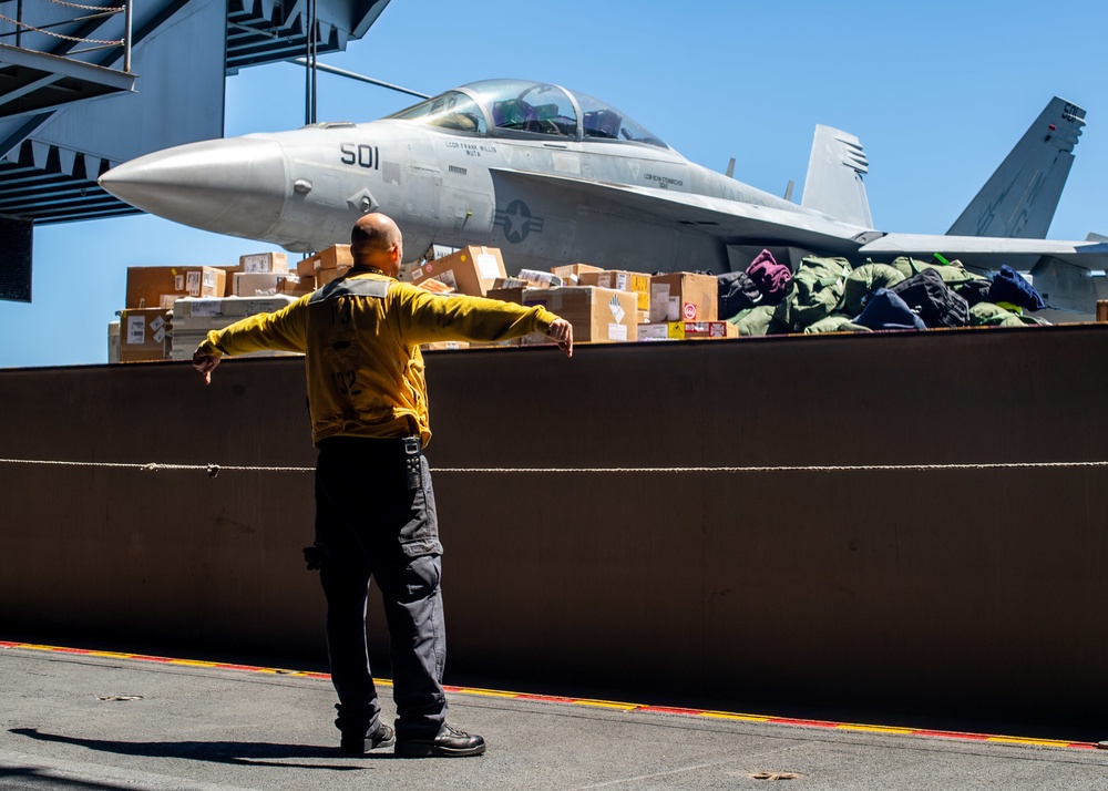 U.S. Sailor signals to lower an aircraft elevator