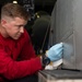 U.S. Sailor conducts corrosion prevention on an F/A-18F Super Hornet