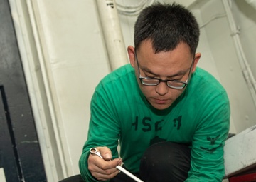 U.S. Sailor conducts maintenance