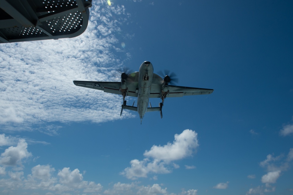 E-2C Hawkeye flies over the aircraft carrier USS John C. Stennis (CVN 74)