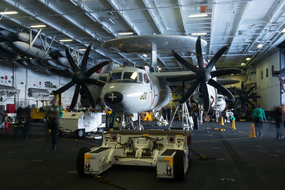 U.S. Sailors transit around an E-2C Hawkeye