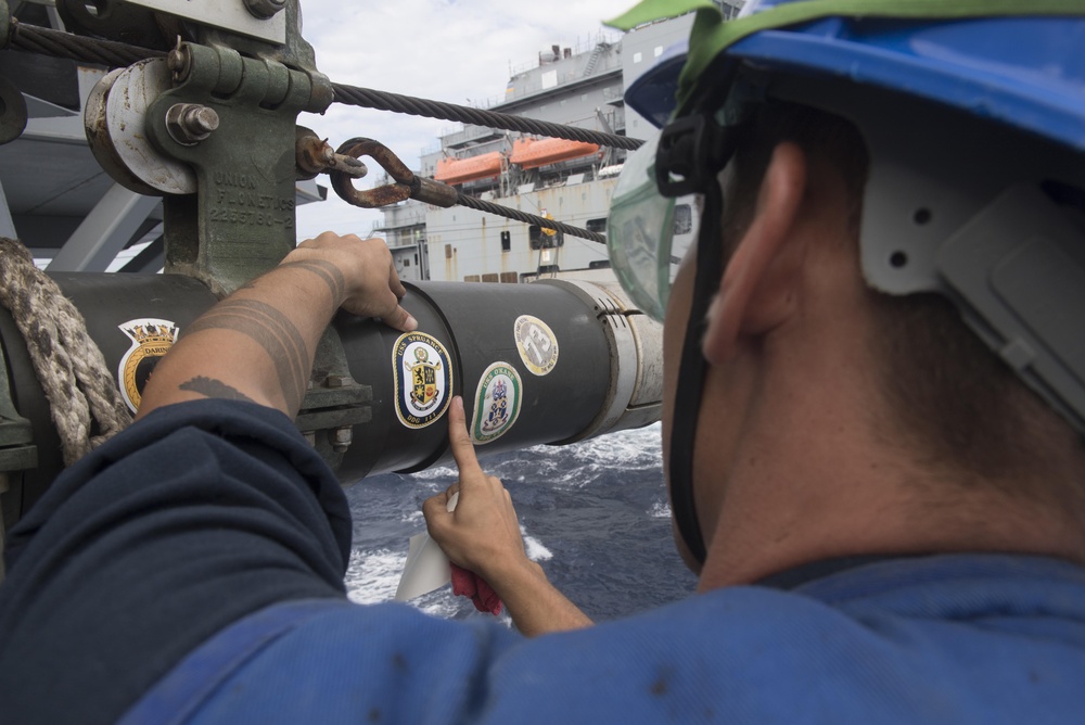 U.S. Navy Sailors assigned to USS Spruance conduct a replenishment-at-sea with USNS Cesar Chavez