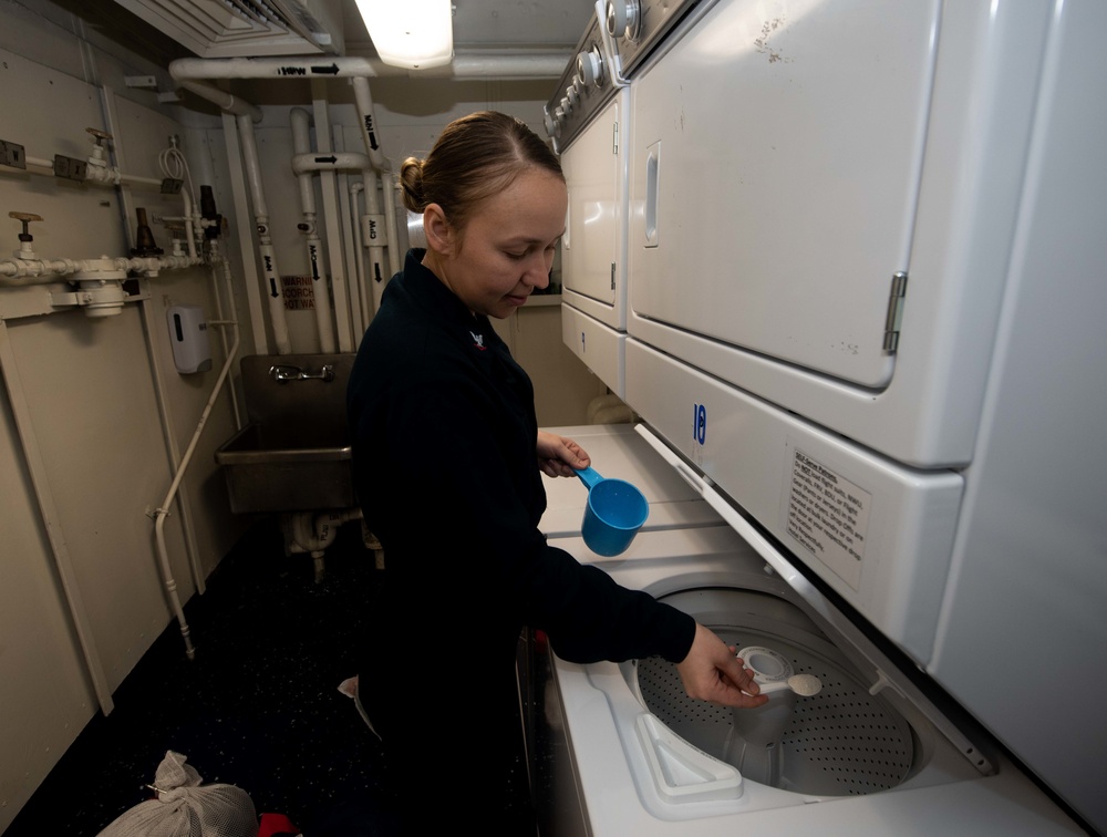 U.S. Sailor prepares a load of laundry