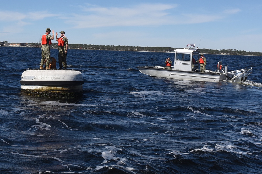 Boatswain's Mate 1st Class Taylor Baxley reenlists atop mooring bouy