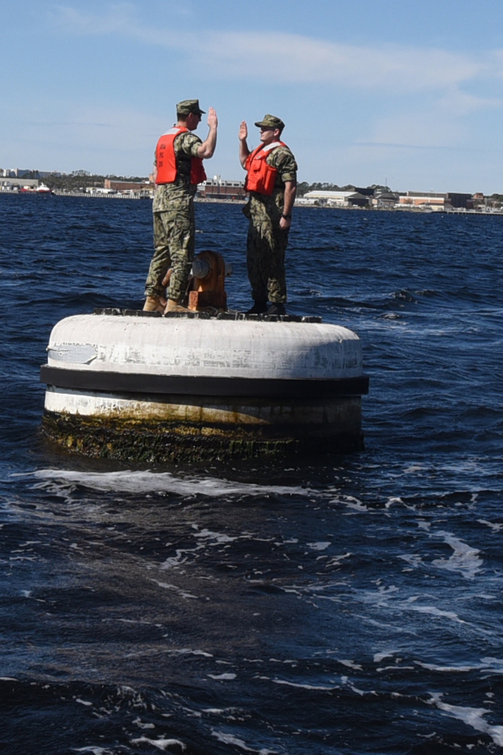 Boatswain's Mate 1st Class Taylor Baxley reenlists atop mooring bouy