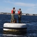 Boatswain's Mate 1st Class Taylor Baxley reenlists atop mooring bouy