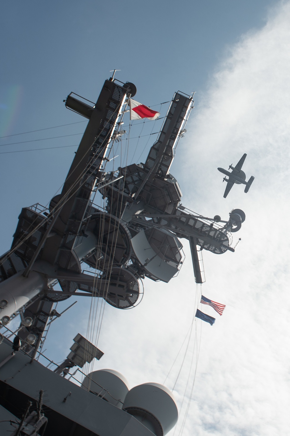 An E-2C Hawkeye flies over the aircraft carrier USS John C. Stennis (CVN 74)