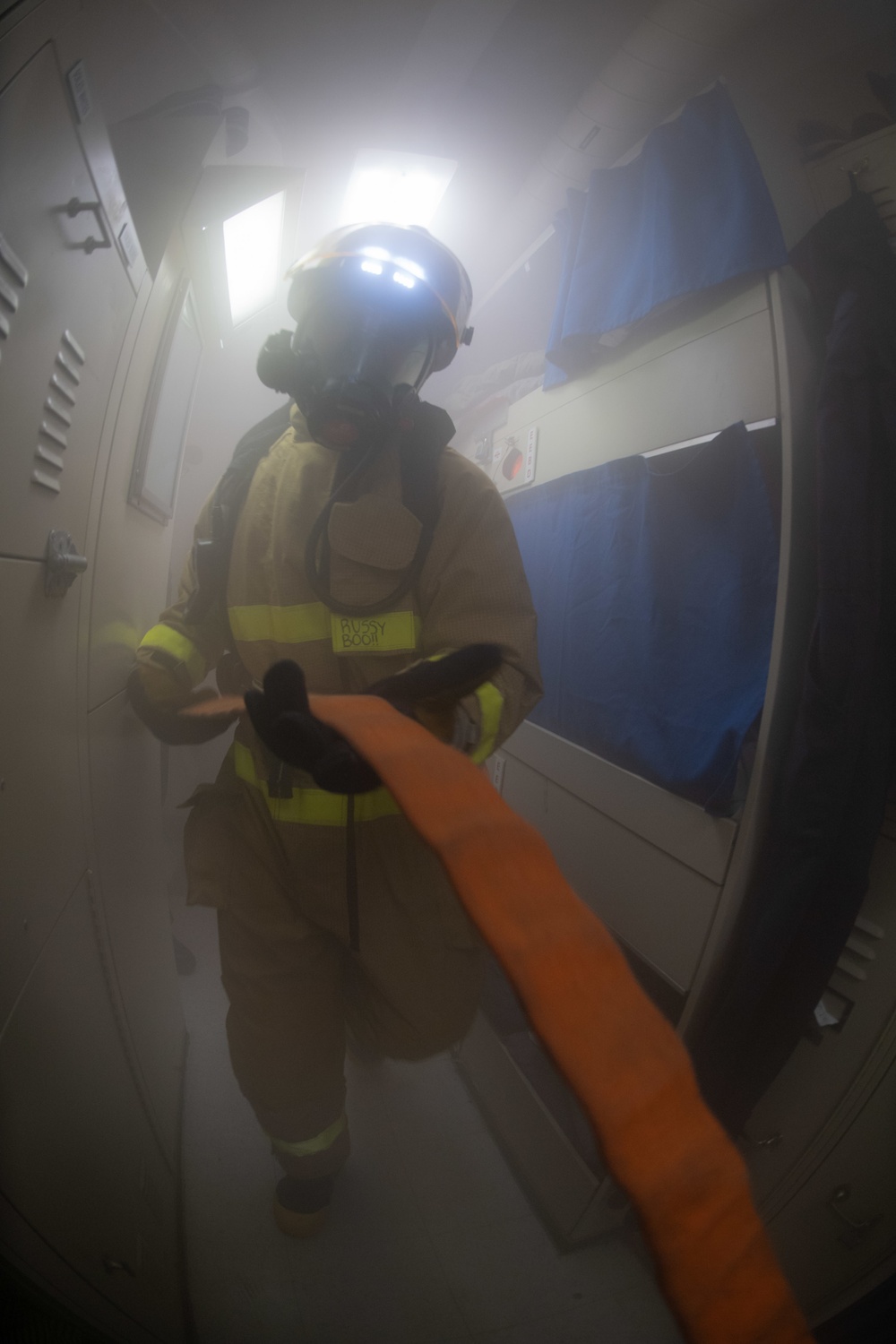 U.S. Sailor transits a berthing during a simulated fire