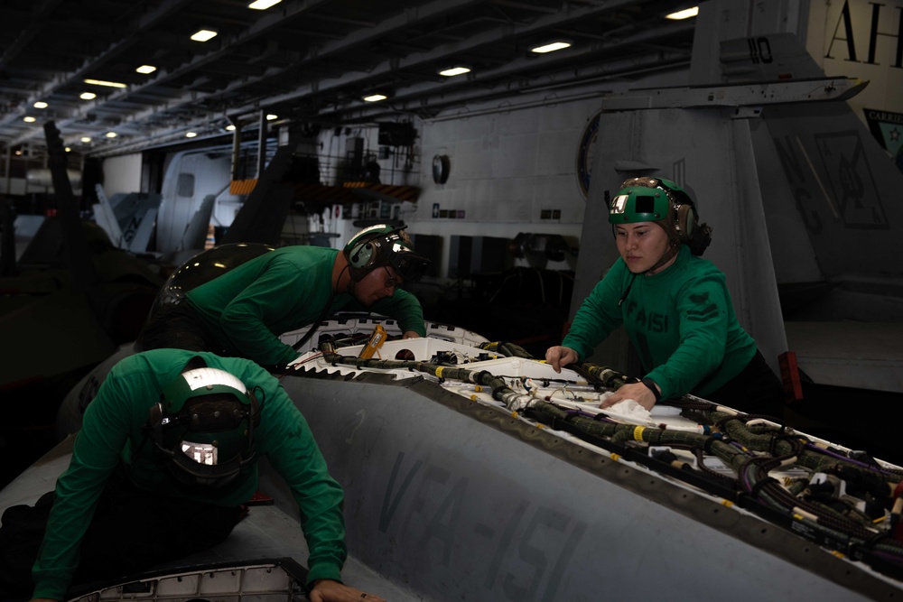 U.S. Sailors inspect an F/A-18E Super Hornet