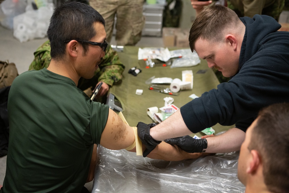 Marines and JGSDF soldiers give each other IVs