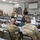 A briefing or training session is taking place in a conference room at what appears to be a Texas Department of Public Safety facility. Military personnel in Army Combat Uniforms (ACU/OCP camouflage) are seated at rows of tables facing a civilian presenter at a podium. Posters labeled 'Counterdrug' are visible on the walls, indicating this is likely a National Guard Counterdrug Program meeting.