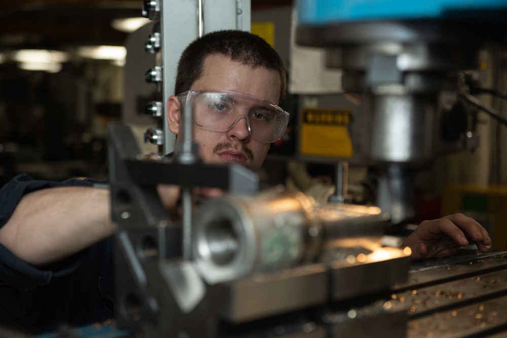 U.S. Sailor files down a tool for a stanchion