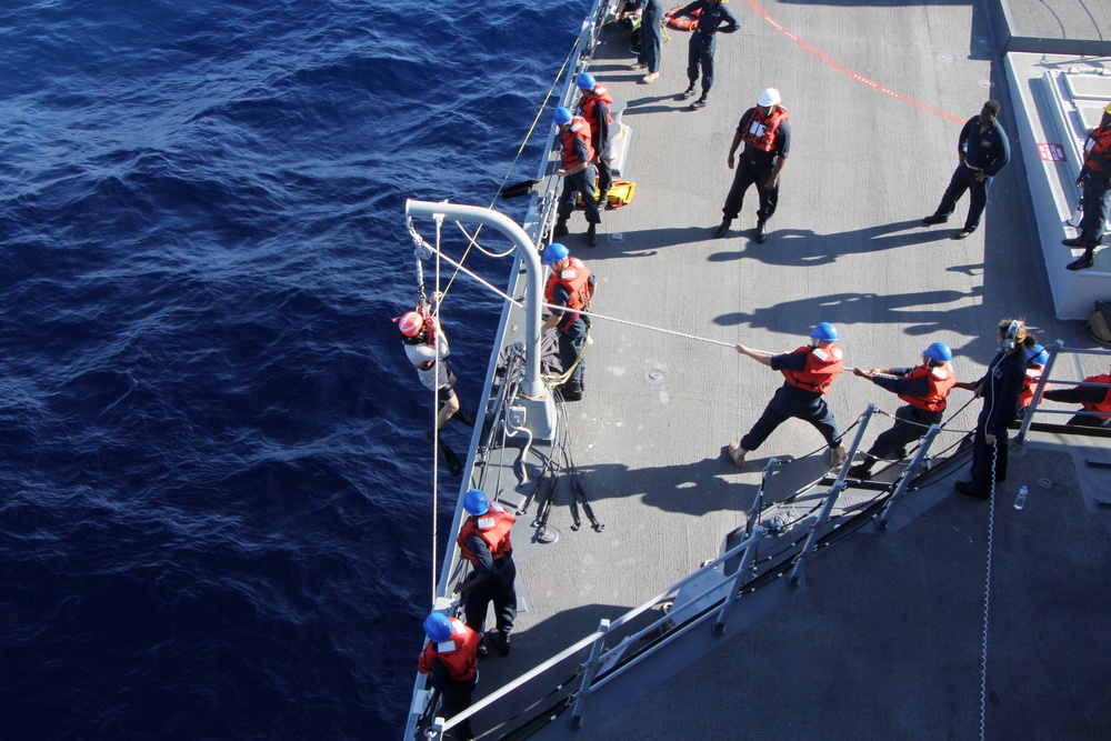 U.S. Navy Sailors recover a simulated man overboard during a man overboard drill aboard USS Spruance.