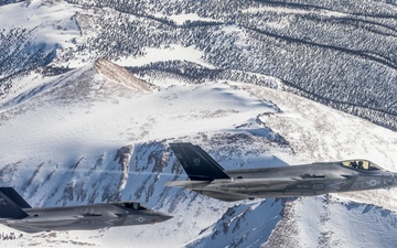 Two F-35C's Fly Over Snow Covered Serria Mountains