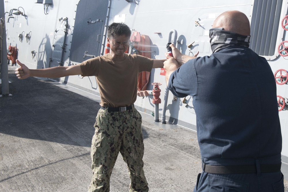 U.S. Navy Sailors participate in a between the lifelines course aboard the USS Spruance.