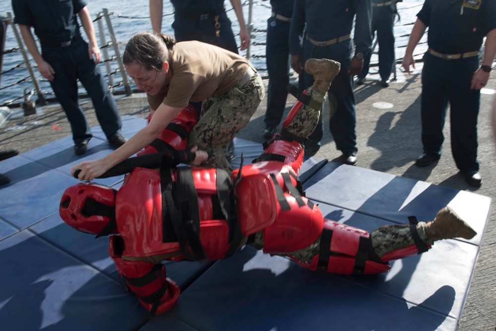 U.S. Navy Sailors participate in a between the lifelines course aboard the USS Spruance.