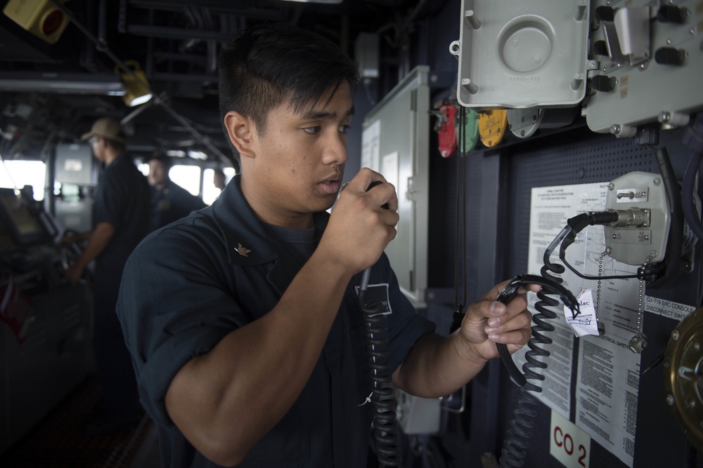 U.S. Navy Sailors Stand watch in the pilot house aboard the USS Spruance.