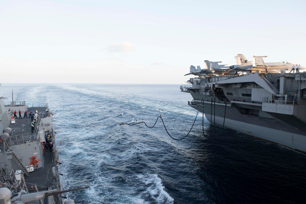 The USS Spruance conducts a replenishment-at-sea with the aircraft carrier USS John C. Stennis.