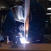 U.S. Sailor welds metal