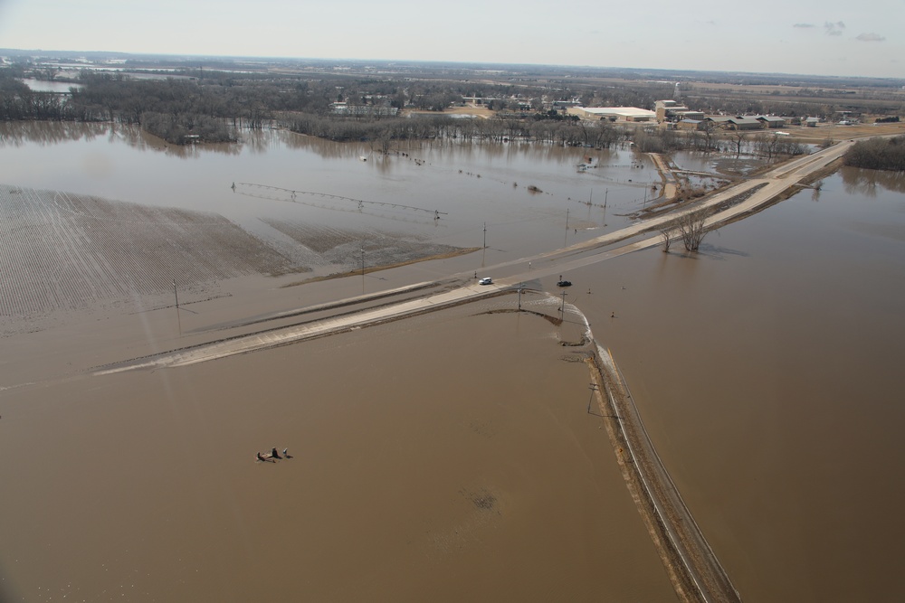 A section of road is underwater stranding a vehicle near Waterloo, Nebraska