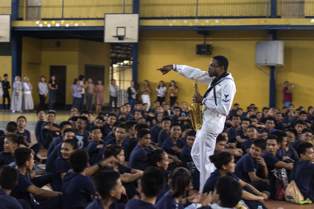 Musician 3rd Class Jared Goodrum, assigned to the U.S. 7th Fleet Band, performs for students at the Tuloy Foundation